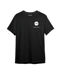 Schwarzes T-Shirt aus Baumwolle mit Rundhalsausschnitt und kurzen Ärmeln. Auf der Vorderseite befindet sich ein weißer Schriftzug "Tradition at Heart". Schlichtes Design ohne Muster.