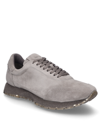 Zapatilla gris de suave ante con cordones. El zapato se caracteriza por su elegante simplicidad y su suela antideslizante.