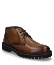 The ankle boot made of brown leather features a distinctive lacing and a robust tread sole. The shoe offers an elegant look with stitched details and a simple design ideal for versatile outfits.