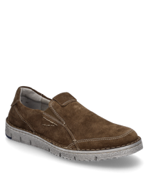 El mocasín marrón de ante cuenta con un cómodo cierre elástico y costuras decorativas visibles. La suela clara complementa el diseño sencillo pero elegante del zapato.