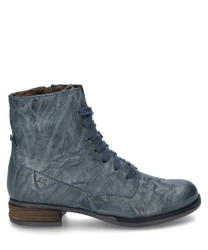 The azure blue leather ankle boot features a side zipper and light brown flat heels. The surface is slightly textured giving the shoe a trendy vintage look.