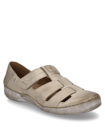 Zapato semiabierto de cuero beige con cierre de velcro. Las características especiales son los lados abiertos y la suela blanca que le dan al zapato un aspecto informal.