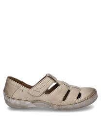 Zapato semiabierto de cuero beige con cierre de velcro. Las características especiales son los lados abiertos y la suela blanca que le dan al zapato un aspecto informal.