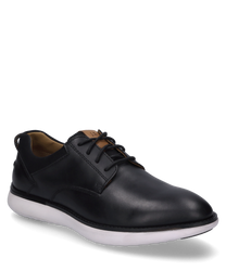 Zapato elegante de cuero negro con cordones. El zapato tiene una suela blanca en contraste y detalles de costura sutiles que le dan un toque moderno al diseño clásico.