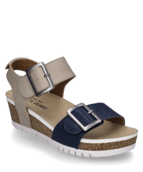 Diese Sandale in 'ocean-kombi' ist aus Leder gefertigt und besitzt einen Klettverschluss. Sie kombiniert beige und dunkelblaue Farbtöne mit auffälligen silbernen Schnallen auf einem Korkfußbett.