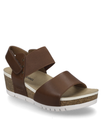 Brown sandal with Velcro closure made of leather and textile material. The sole is made of cork with a white rubber layer that provides comfort and slip resistance.