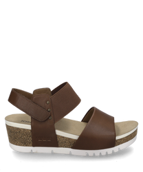 Brown sandal with Velcro closure made of leather and textile material. The sole is made of cork with a white rubber layer that provides comfort and slip resistance.