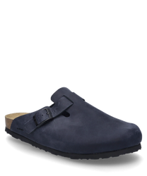 El zueco en color vaquero está hecho de un material suave y mate y cuenta con una hebilla distintiva como cierre. La suela está fabricada de corcho y ofrece un contraste natural con el material superior azul oscuro.