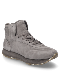 Zapatilla gris de suave ante con cordones. El zapato se caracteriza por su suela robusta y sutiles costuras decorativas en el talón.