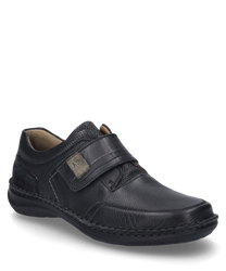 The shoe is black and made of smooth leather with a Velcro strap for easy wear. It features subtle stitching details and a padded collar for added comfort.