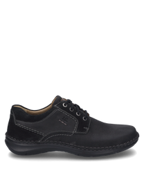 The shoe is black and made of a sturdy material ideal for everyday use. It features lacing and striking white stitching as a special detail.