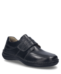 Ein schwarzer Halbschuh mit Klettverschluss aus glattem Leder. Der Schuh hat eine robuste Sohle und dezente Ziernähte auf der Außenseite.