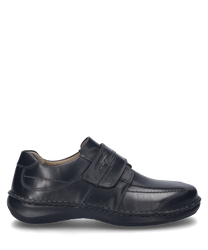 Ein schwarzer Halbschuh mit Klettverschluss aus glattem Leder. Der Schuh hat eine robuste Sohle und dezente Ziernähte auf der Außenseite.