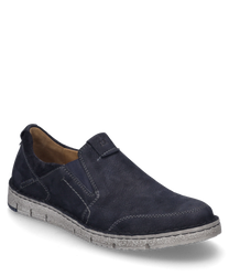 Le chausson de couleur Océan est fabriqué dans un matériau doux de couleur bleu foncé avec une fermeture élastique. La semelle est robuste et de couleur gris clair ce qui donne à la chaussure un look sportif.