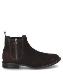 Die Stiefelette in der Farbe Moro besteht aus hochwertigem Wildleder und verfügt über einen seitlichen Reißverschluss. Sie hat eine glatte elegante Form mit einer robusten schwarzen Sohle.