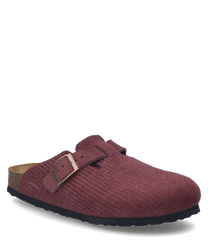 Le sabot de couleur Berry dispose d'une boucle visible comme fermeture. Le matériau a une texture et la semelle a un aspect naturel.