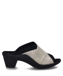 Zuecos de color beige con elástico fabricados en material brillante. El zapato tiene un tacón negro estable y un diseño abierto.