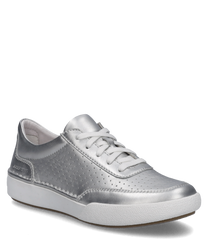 La sneaker argentée se distingue par son matériau lisse et brillant avec des perforations discrètes sur les côtés. Équipée d'un laçage elle offre un look moderne et sportif.