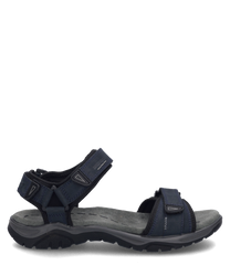 La sandale représentée en couleur indigo est fabriquée à partir d'un matériau robuste et dispose d'une fermeture velcro pratique. La semelle est ergonomiquement conçue pour offrir un confort optimal.