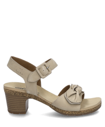 Sandale beige avec fermeture velcro et nœud décoratif. La chaussure a un talon bloc de hauteur moyenne avec un aspect liège et est fabriquée en matériau lisse.