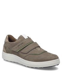 De sneaker in taupe-multi valt op door zijn klittenbandsluiting en de combinatie van glad en suède. De witte zool en de groene accentstiks geven de schoen een moderne en sportieve uitstraling.