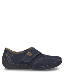 El zapato en color Océano está hecho de un material estructurado y cuenta con un práctico cierre de velcro. Destacan las costuras en contraste y el discreto detalle del logo en el costado.