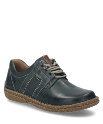 Der Halbschuh ist aus tannengrünem Leder gefertigt und besitzt eine robuste hellbraune Sohle. Besondere Merkmale sind die dekorativen Nähte und die Schnürung die für einen klassischen Look sorgt.