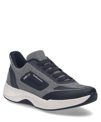 La zapatilla en negro y blanco está hecha de un material transpirable y estampado con detalles en contraste. Cuenta con un práctico cierre elástico de goma para poner y quitar fácilmente.