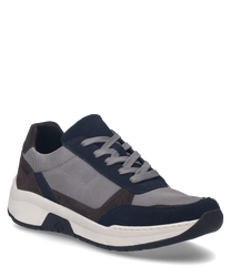La sneaker nella variante di colore 'ocean-multi' combina inserti in tessuto grigio e blu marino con accenti in suede marrone scuro. È dotata di una chiusura con lacci e si distingue per una comoda suola in gomma bianca.