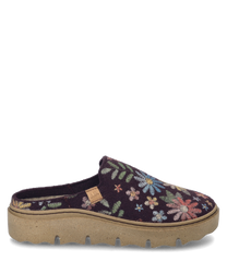 Un zapato de casa en color "morado-múltiple" con un patrón floral y sin cierre. El zapato está hecho de un material suave con una suela estable de color beige con patrón.