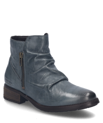 La bota azul destaca por su suave cuero y un elegante cierre de cremallera en el lateral. El zapato tiene una superficie texturizada y una suela robusta de color marrón oscuro ideal para los días de otoño con estilo.