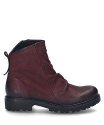 La bota de cuero color burdeos cuenta con una cremallera lateral y una suela robusta y perfilada. El zapato se destaca por su elegante fruncido en la parte delantera.
