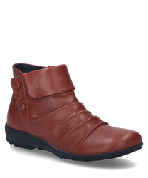 La botte en couleur rubis est en cuir lisse et dispose d'une fermeture éclair pratique. Les détails décoratifs des boutons sur le côté et l'aspect légèrement froncé du cuir sont particulièrement remarquables.