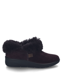 Une pantoufle en velours de couleur aubergine sans fermeture. La chaussure a un col en fausse fourrure pour un confort supplémentaire.