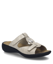 These sandals feature a beige leather upper with a Velcro strap closure for easy adjustment. The ergonomic design includes a cushioned sole for comfort and a subtle shimmer for a touch of elegance.