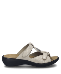 These sandals feature a beige leather upper with a Velcro strap closure for easy adjustment. The ergonomic design includes a cushioned sole for comfort and a subtle shimmer for a touch of elegance.