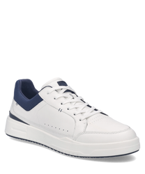 Weißer Sneaker aus Leder mit blauer Ferse und Schnürung. Schlichtes Design mit Perforationen an den Seiten für Atmungsaktivität.