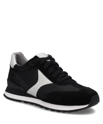 Schwarzer Sneaker aus Textil und Veloursleder mit weißem Seitenstreifen. Die Schnürung und die profilierte Sohle sind gut sichtbar.
