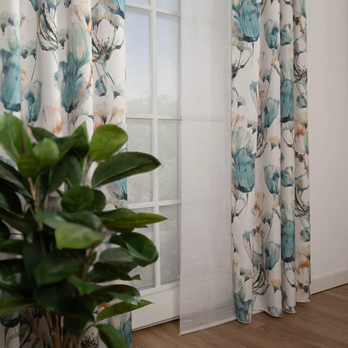 Florale Vorh&auml;nge mit blauen Bl&uuml;ten am Sprossenfenster