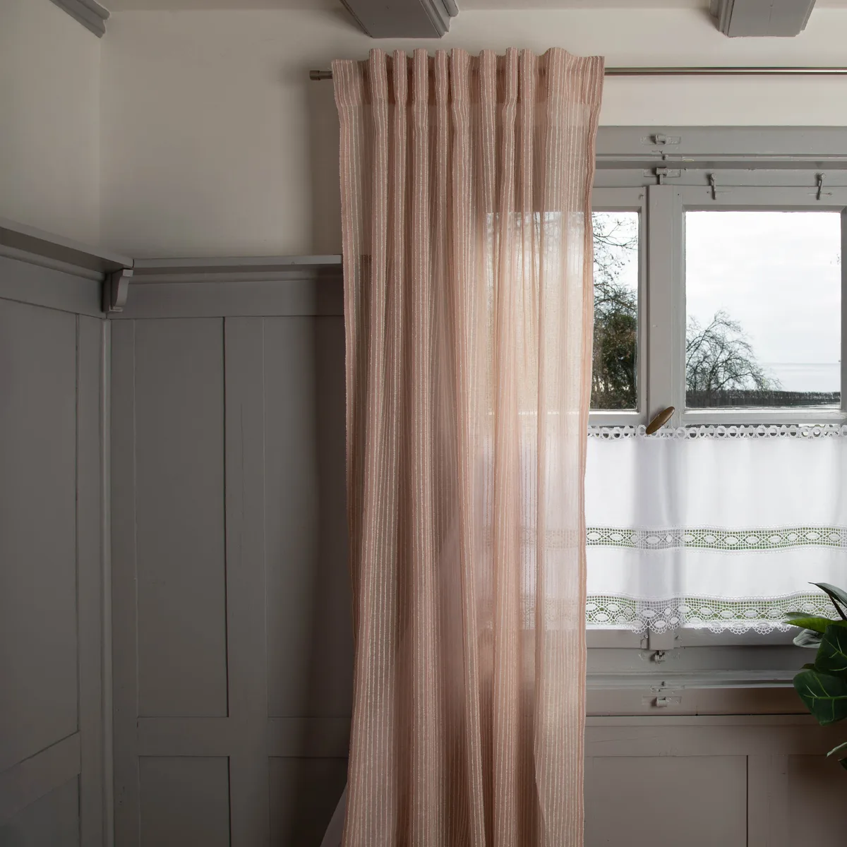 Transparenter raumhoher Store mit Streifen in Rosé am Fenster