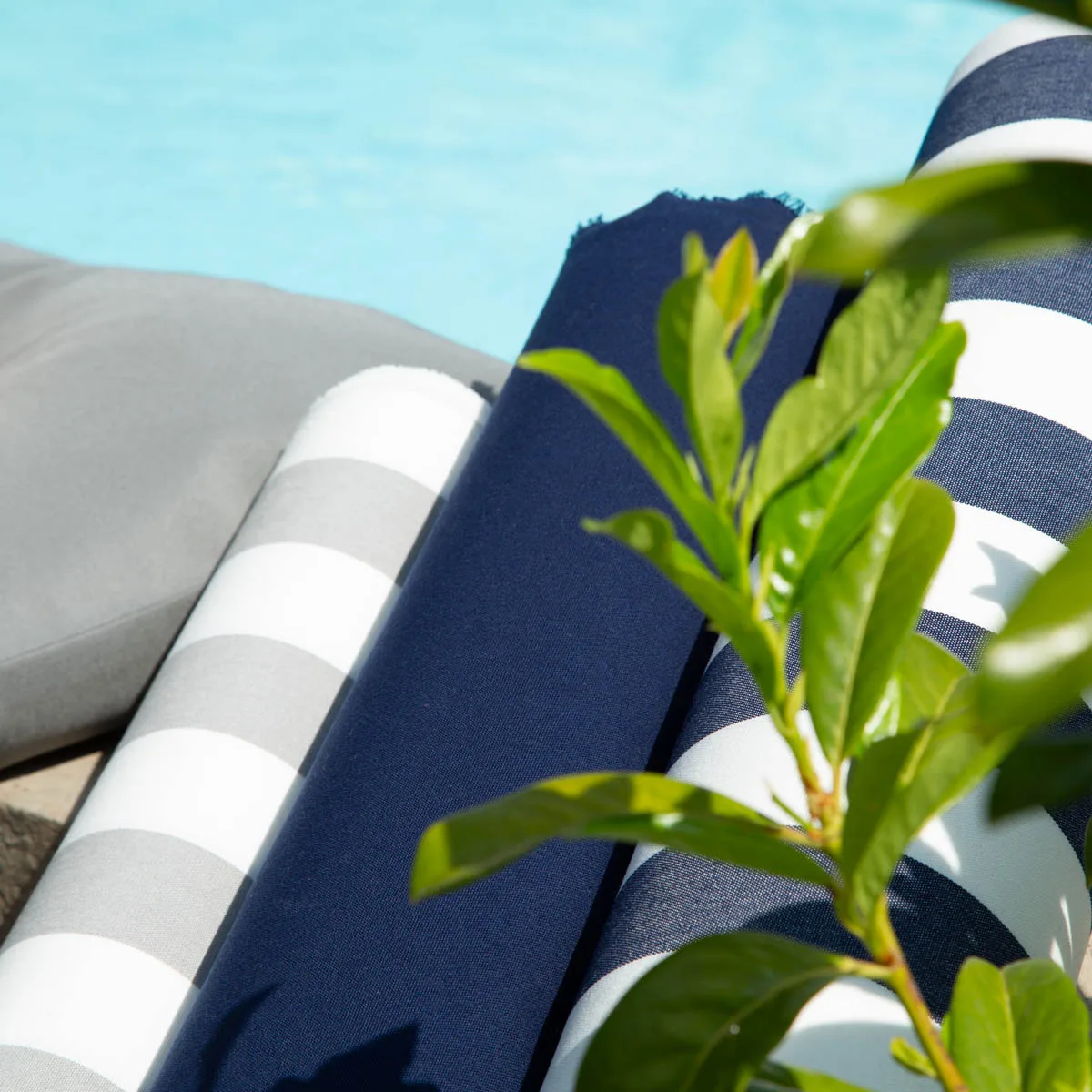 Outdoor-Markisenstoff-Rollen in Marineblau und Grau-Weiß gestreift am Pool