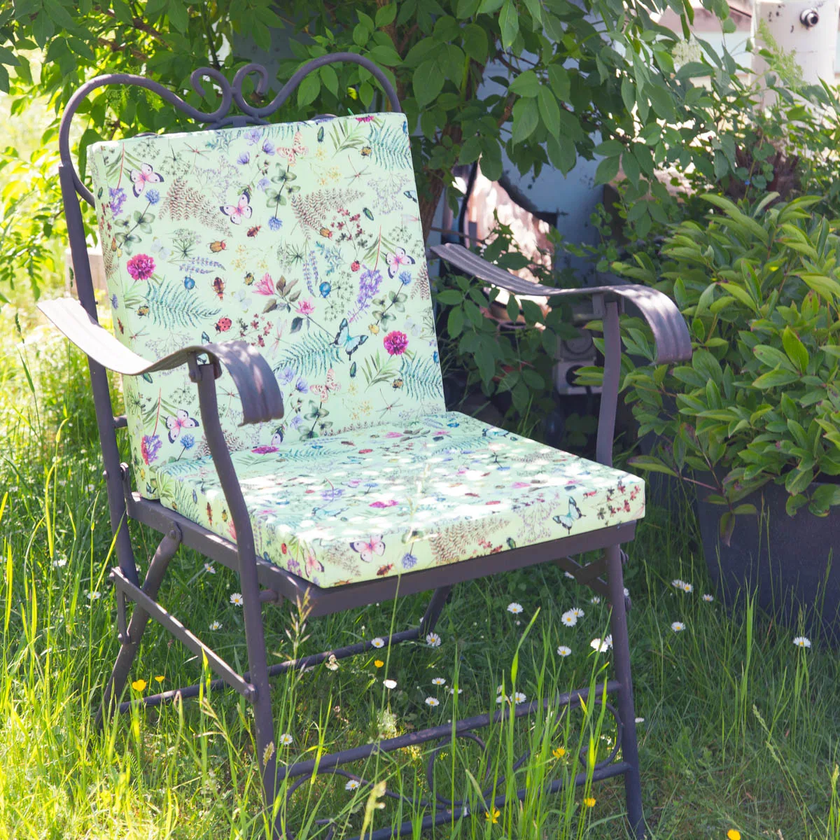 Stuhlkissen mit Blumenmuster auf einem Gartenstuhl aus Metall