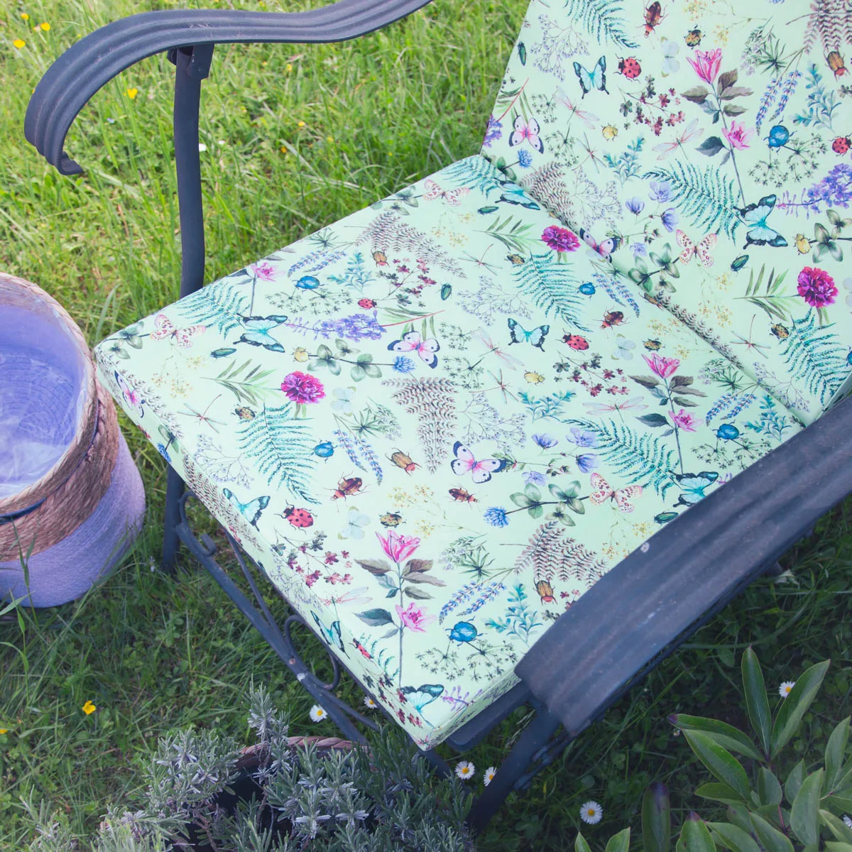 Sitzkissen mit Schmetterlings- und Blumenmuster auf Gartenstuhl – Nahaufnahme