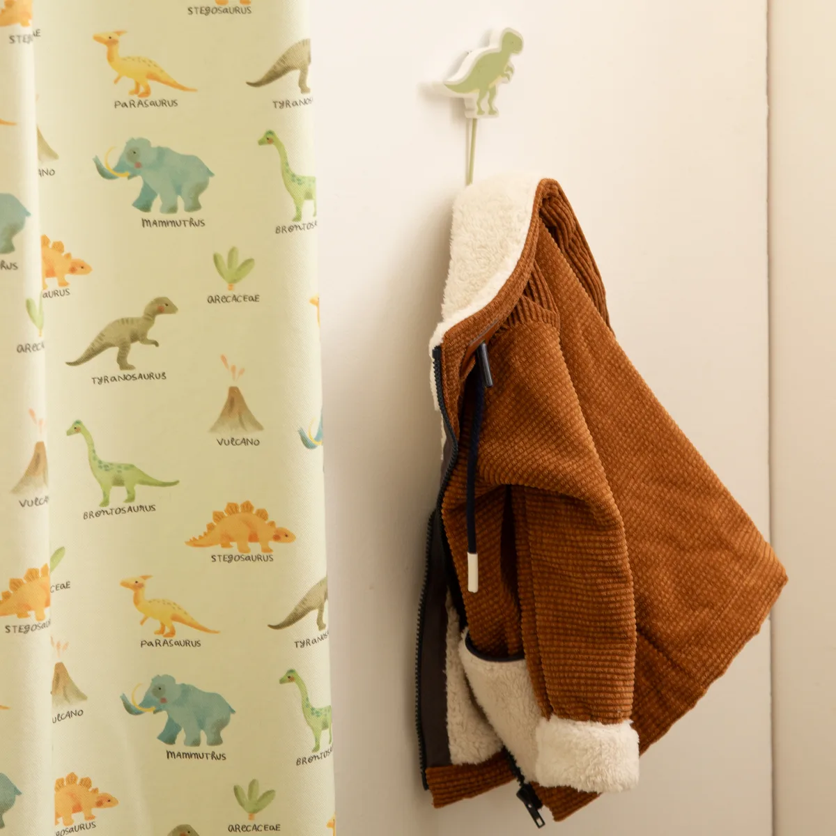 Dinosaurier-Stoff als Bahn im Kinderzimmer mit Garderobenhaken