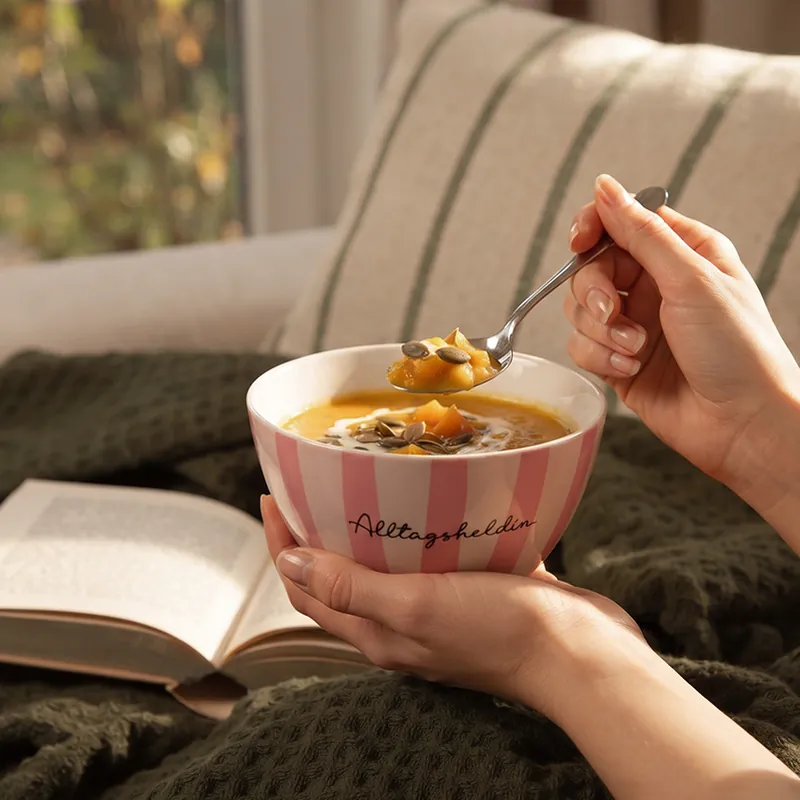 Kürbissuppe auf dem Sofa mit Decke und Buch – Kuschelzeit im Herbst