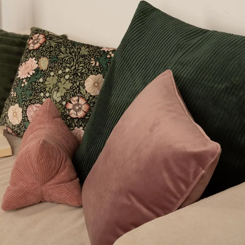 Samtkissen in Grün und Rosa auf dem Sofa