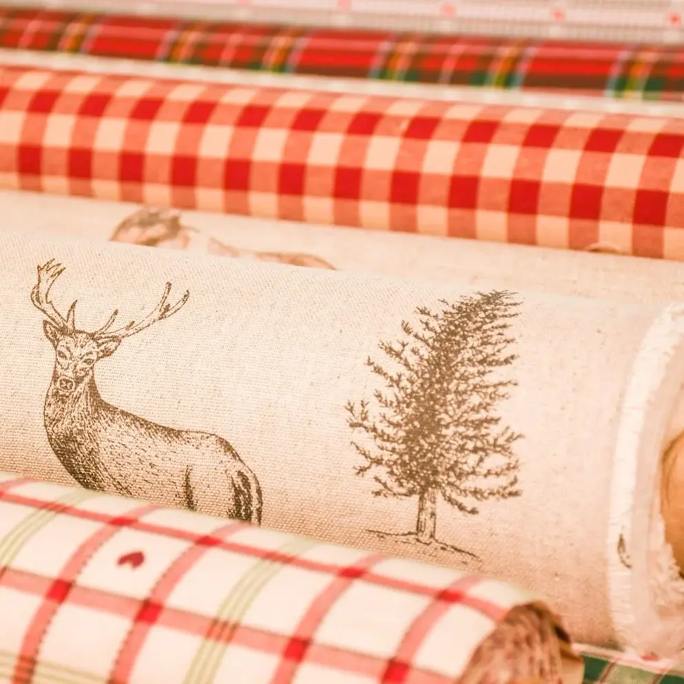 Landhausstoffe als Meterware: Stoffrollen mit Hirsch-Motiv und rotem Karo