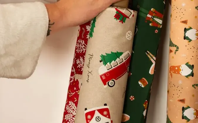 Weihnachtsstoffe als Meterware: Stoffrollen mit Rentier, VW-Bus und Weihnachtsmann