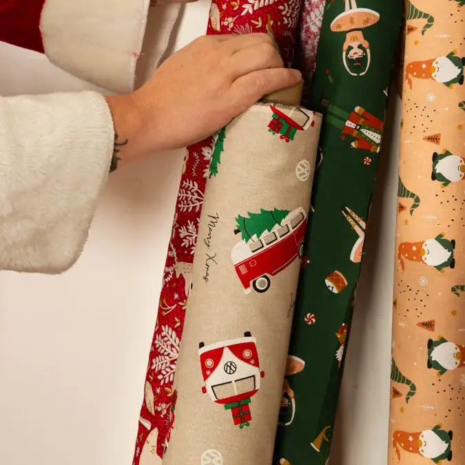 Weihnachtsstoffe als Meterware: Stoffrollen mit Rentier, VW-Bus und Weihnachtsmann