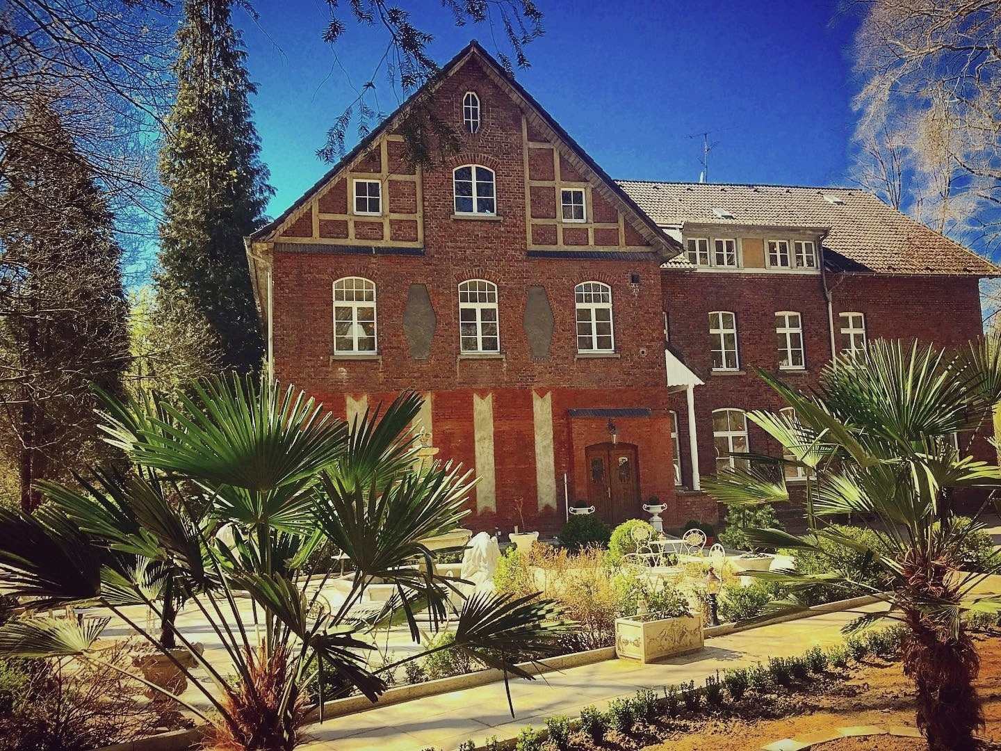 la casa di Casa Padrino a Essen per intero, con frontone a graticcio e giardino di palme